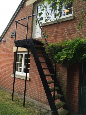 The stairs in this picture lead to the room of C.S. Lewis at The Kilns. The inside door to his room was locked and Lewis lost the key. So, for many years, to get to his office on the other side, he would walk down the stairs, go half way around the house to the front, go inside, and go back up stairs. When he married Joy, that routine changed. Joy got a locksmith to make another key. 